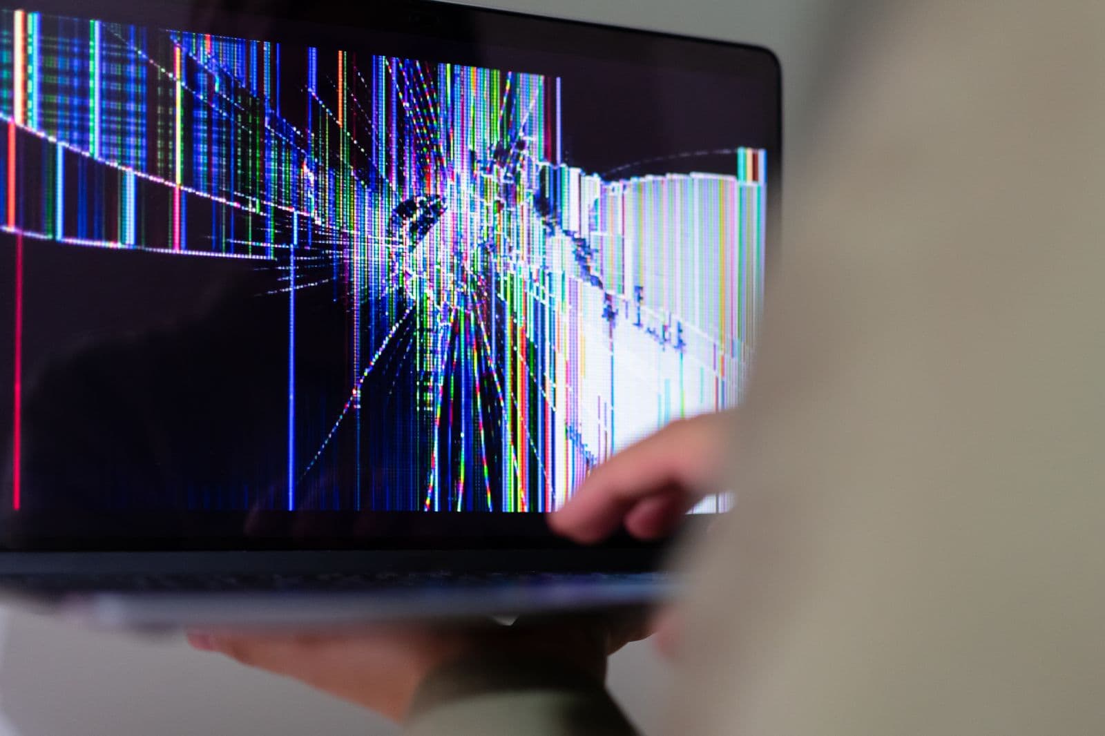 Cracked laptop screen showing colorful pixelated distortion