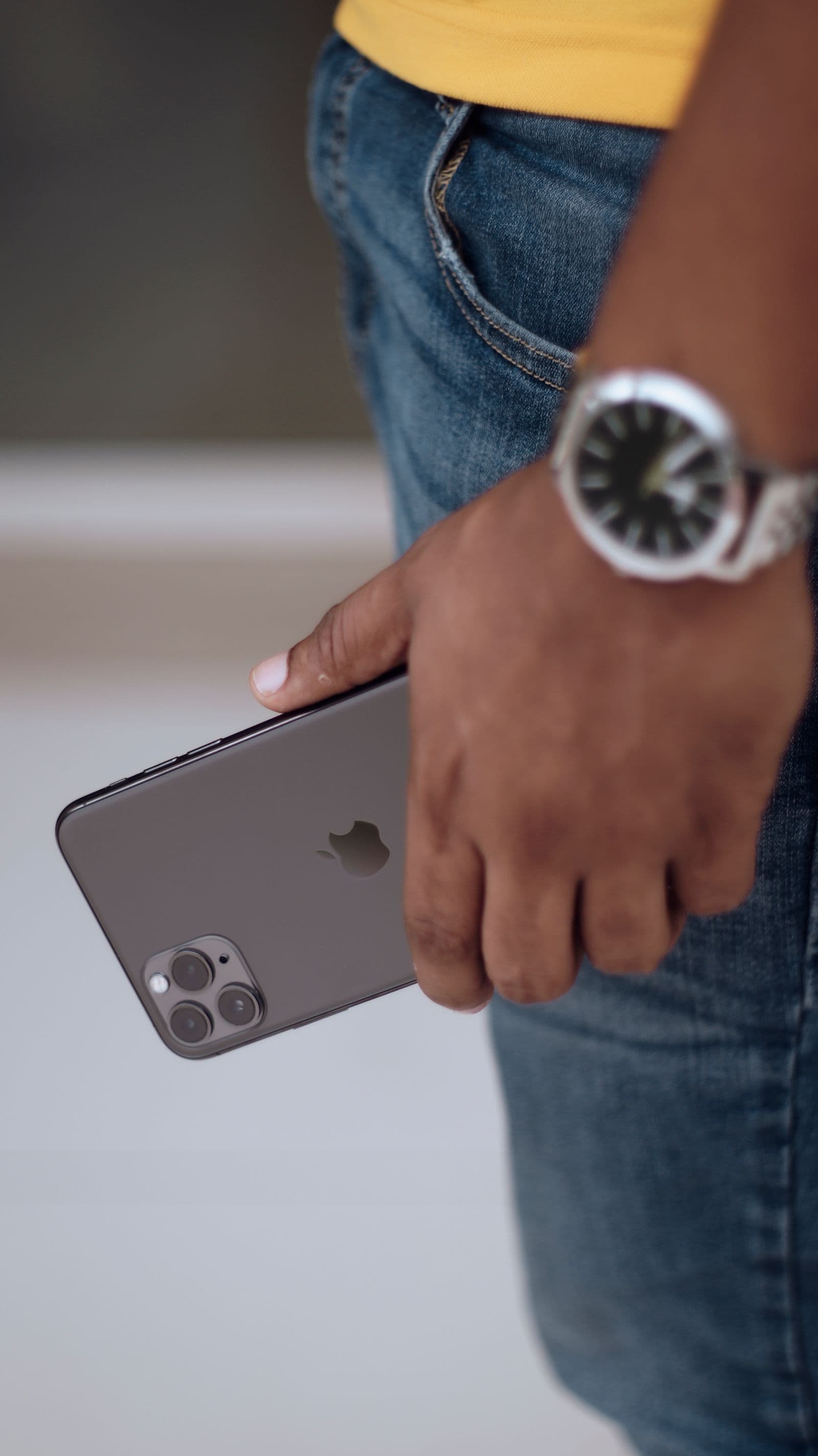 Hand holding a black iPhone outdoors