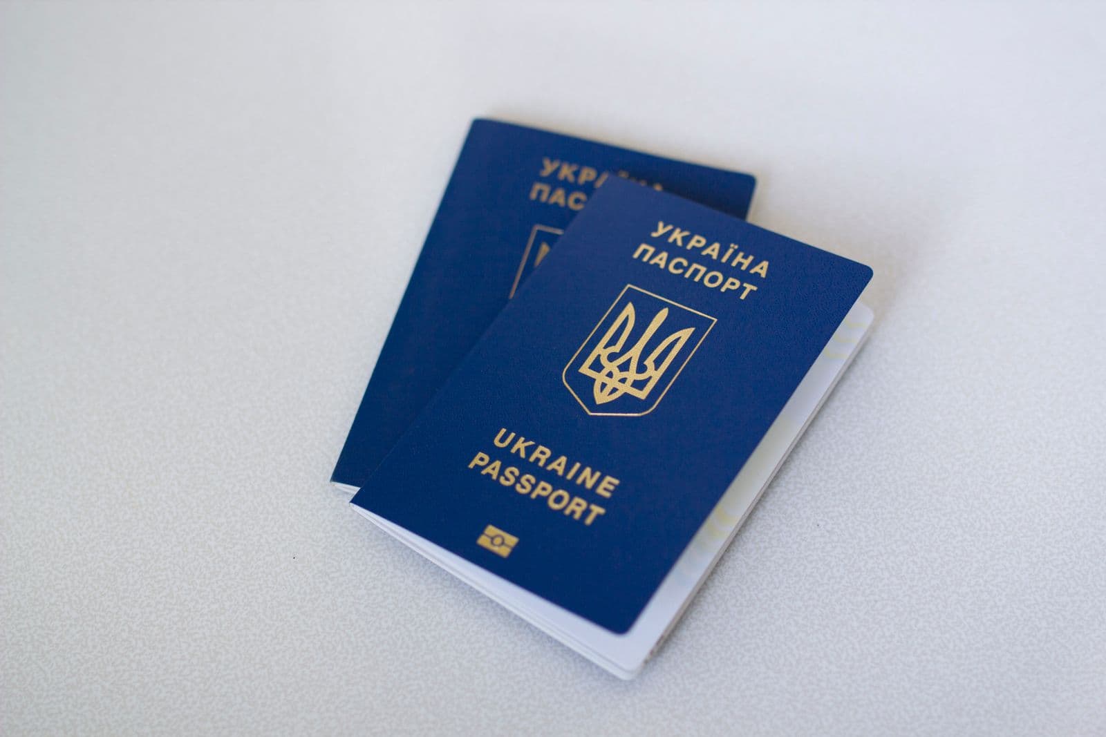 Blue passports stacked closely together on a flat surface