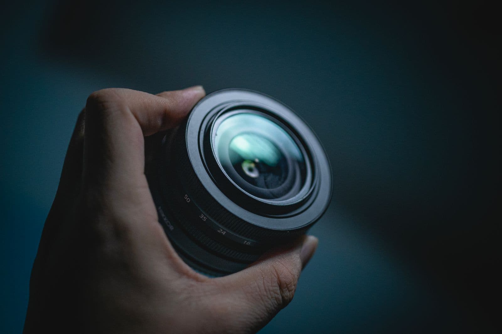 Close-up of a camera lens held in a hand