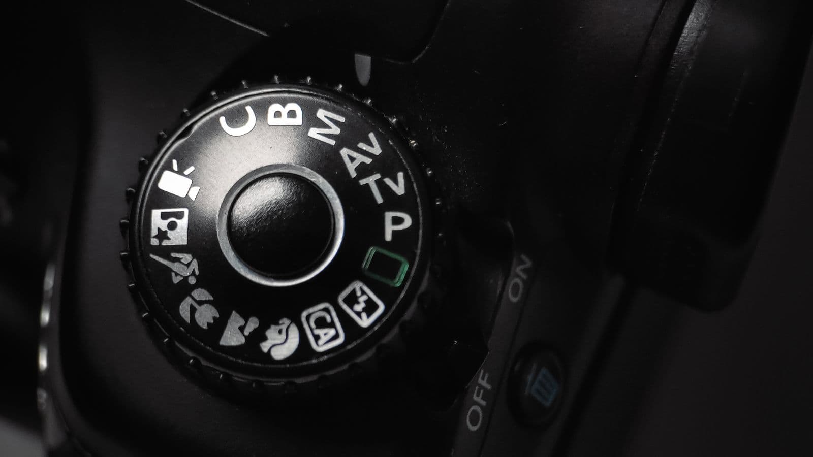 Close-up of a DSLR camera's mode dial with setting icons