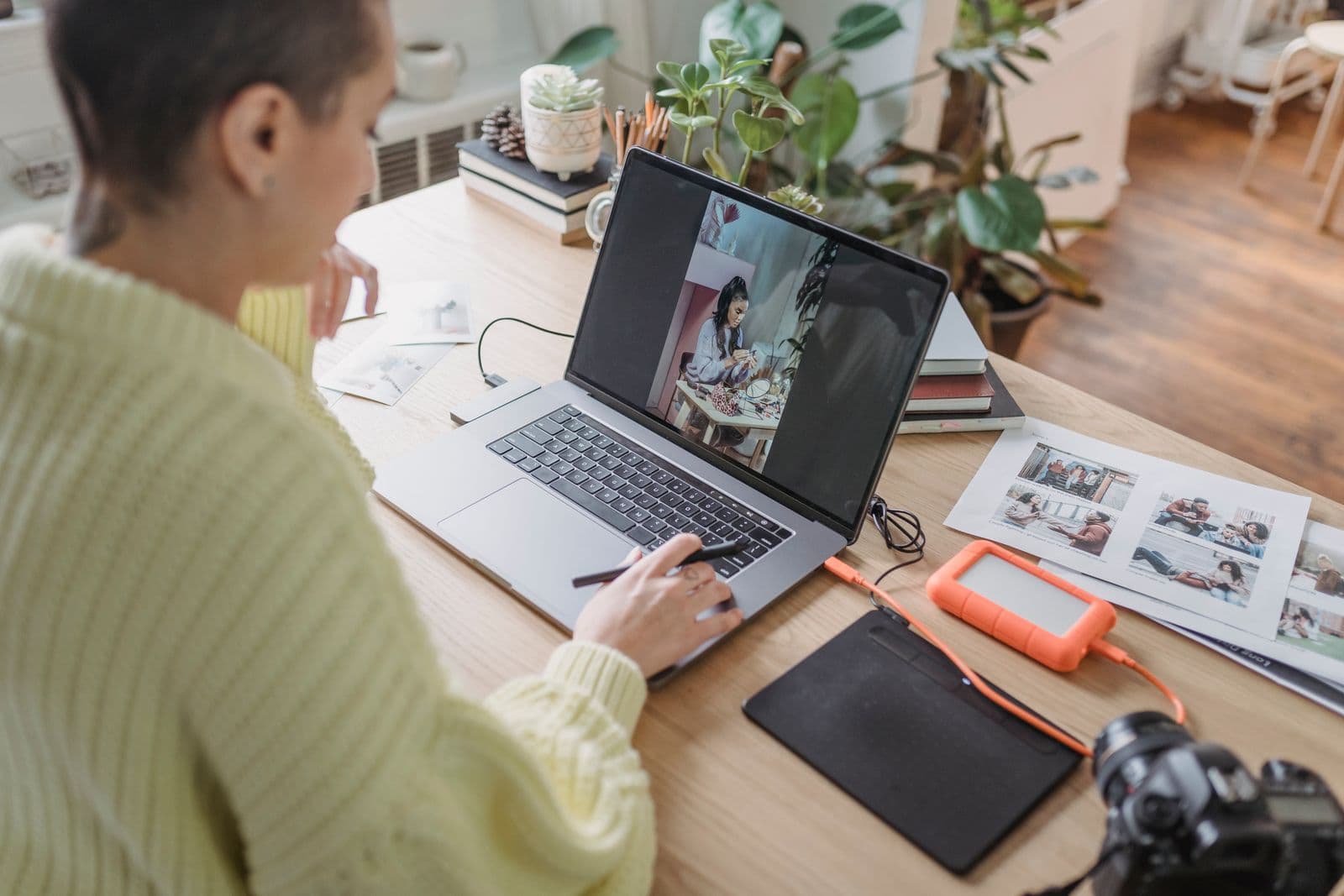 Person editing photos on a laptop while using a graphic tablet
